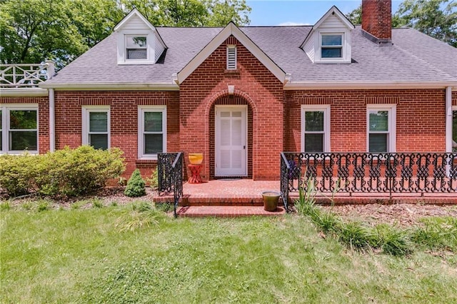 407 E College St E, Bowdon, GA 30108 - new england style home featuring brick siding, a chimney, roof with shingles, a front lawn, and a patio