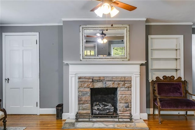 407 E College St E, Bowdon, GA 30108 - living area featuring a ceiling fan, wood finished floors, a stone fireplace, and crown molding