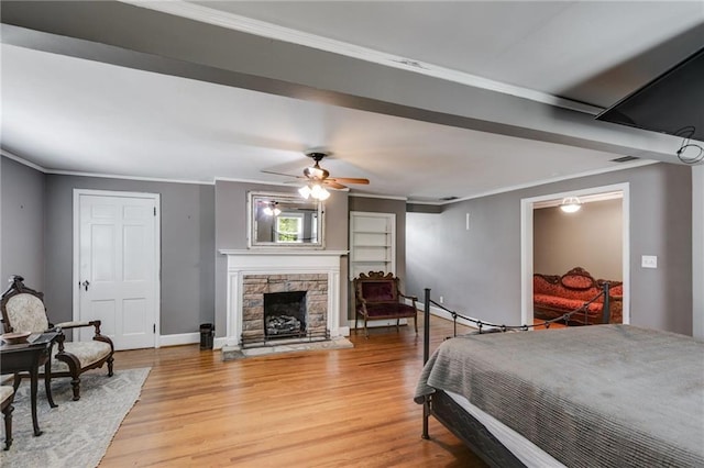 407 E College St E, Bowdon, GA 30108 - bedroom with ornamental molding, light wood-type flooring, and a stone fireplace