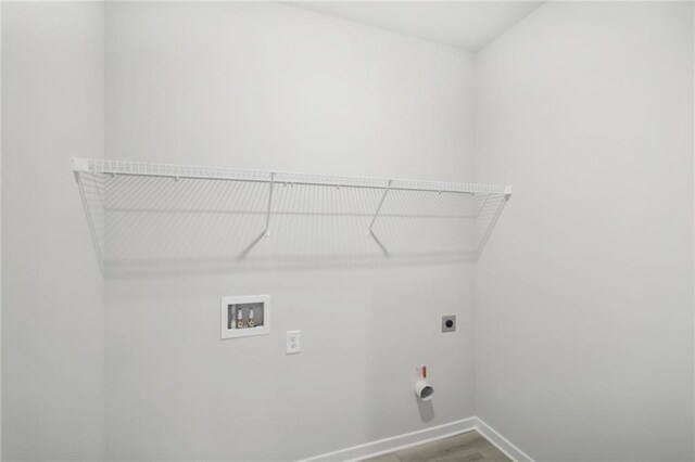 laundry room featuring electric dryer hookup, washer hookup, baseboards, and wood finished floors