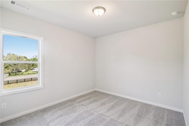 unfurnished room featuring carpet and baseboards