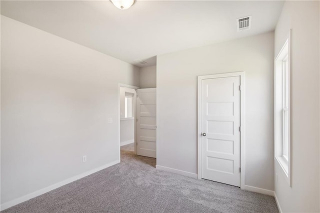 unfurnished bedroom with carpet floors, baseboards, and multiple windows