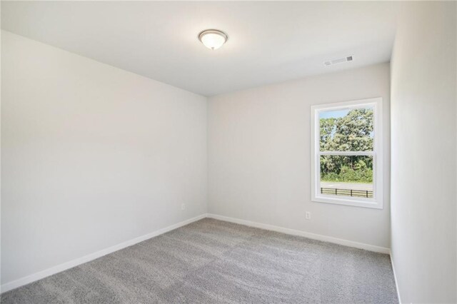 spare room featuring carpet flooring and baseboards