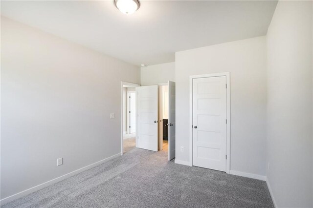 unfurnished bedroom with carpet flooring and baseboards