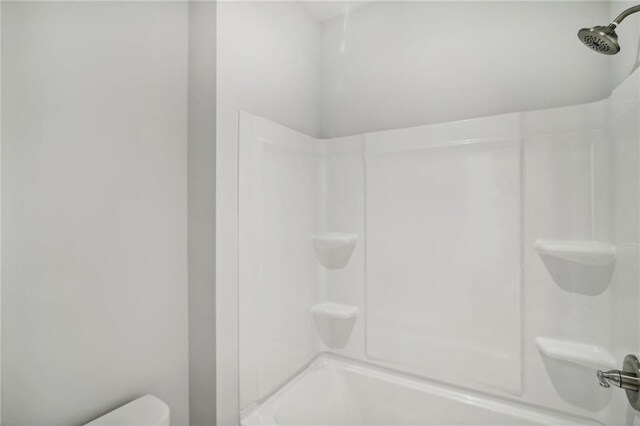 bathroom with bathtub / shower combination and toilet