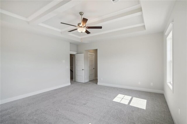 spare room featuring carpet flooring, a raised ceiling, a ceiling fan, and baseboards