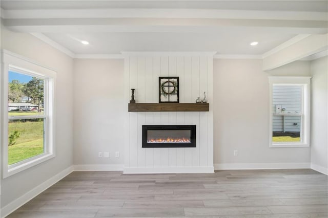 unfurnished living room with crown molding, light wood-style floors, plenty of natural light, recessed lighting, and a fireplace