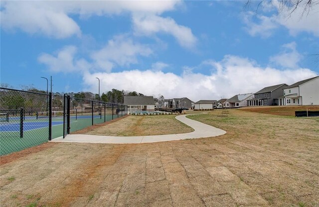 surrounding community with a tennis court and a residential view