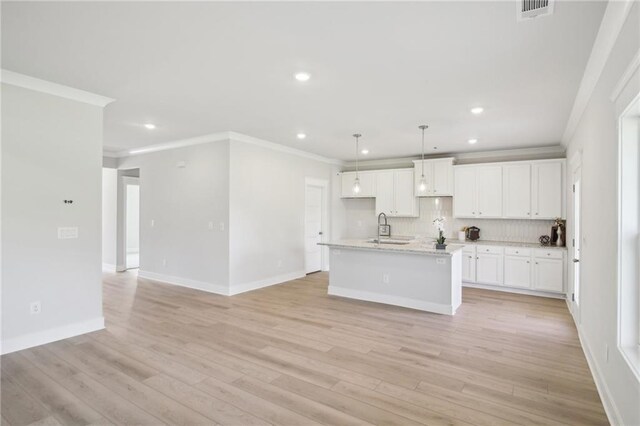 kitchen with ornamental molding, recessed lighting, a sink, tasteful backsplash, and white cabinets