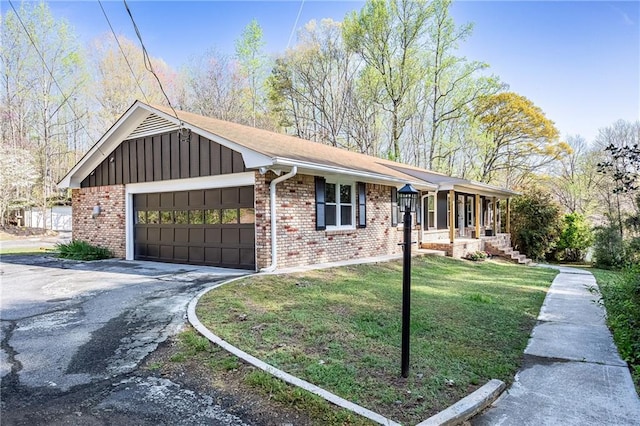 view of front of property with a garage, a front yard, aphalt driveway, and brick siding