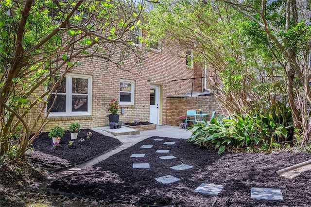 exterior space with a patio and brick siding