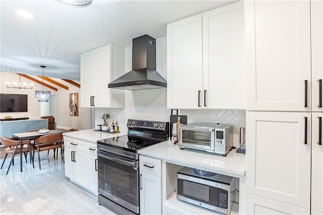 kitchen with light countertops, wall chimney exhaust hood, appliances with stainless steel finishes, and tasteful backsplash