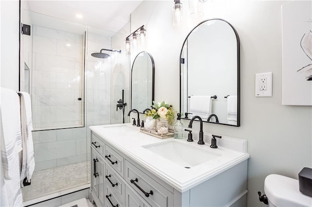 full bathroom with double vanity, a sink, and a tile shower