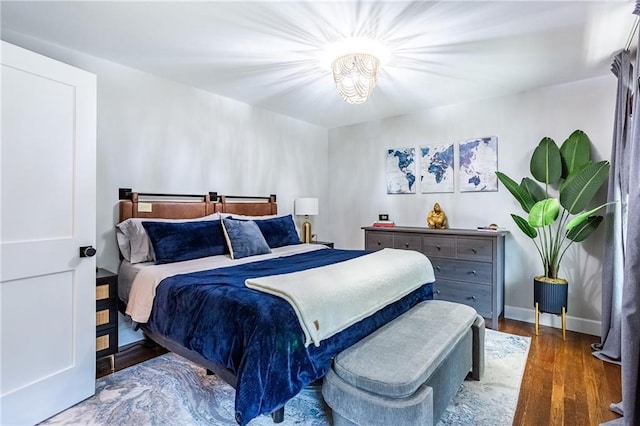 bedroom with baseboards and wood finished floors