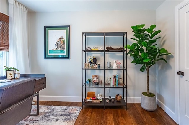 living area featuring baseboards and wood finished floors