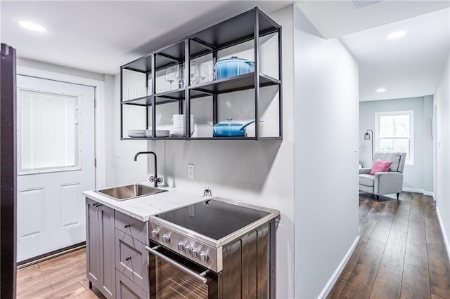 bar featuring wood finished floors, baseboards, recessed lighting, a sink, and stainless steel electric range oven