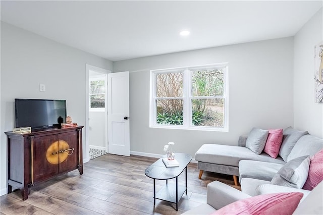 living room featuring recessed lighting, baseboards, and wood finished floors
