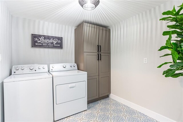 washroom with baseboards, cabinet space, and washer and dryer