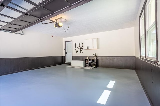 garage with wainscoting and a garage door opener