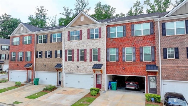 multi unit property featuring a garage, driveway, brick siding, and board and batten siding