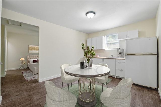 dining area with baseboards and wood finished floors