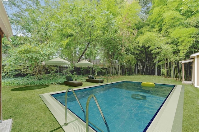 view of pool with a fenced backyard and a yard