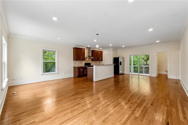 unfurnished living room with light wood-style floors, baseboards, and ornamental molding