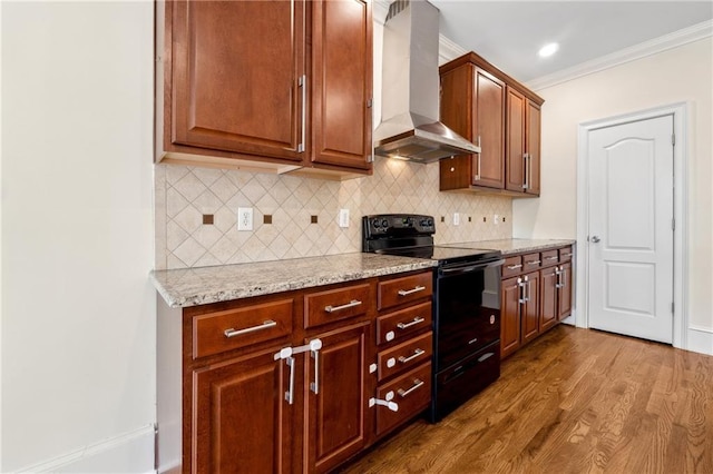 kitchen featuring tasteful backsplash, island range hood, wood finished floors, crown molding, and black electric range