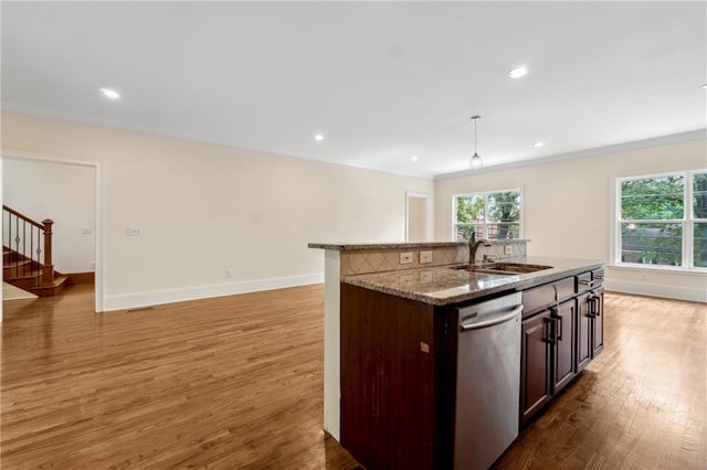 kitchen featuring light stone counters, light wood-style flooring, a sink, baseboards, and stainless steel dishwasher