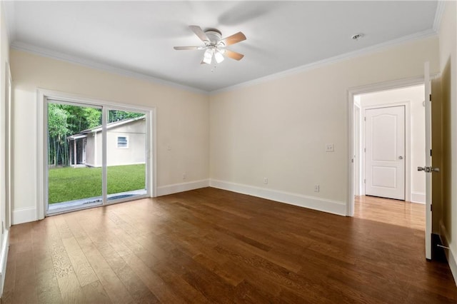 spare room with baseboards, wood finished floors, and crown molding