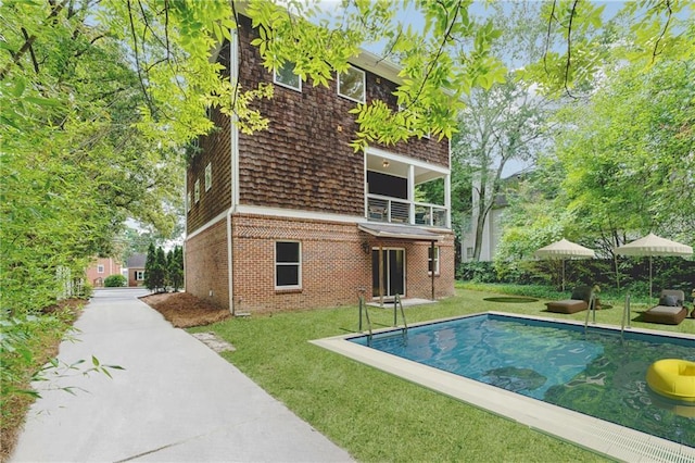 outdoor pool featuring a yard