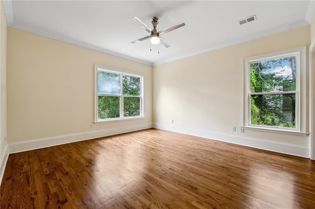 unfurnished room featuring baseboards, visible vents, a ceiling fan, ornamental molding, and wood finished floors