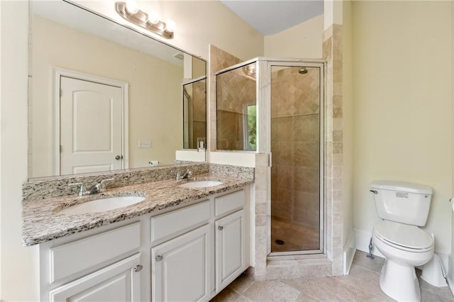 bathroom with double vanity, a stall shower, toilet, and a sink