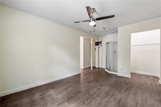 unfurnished bedroom featuring dark wood-type flooring, a wall mounted AC, a ceiling fan, and baseboards