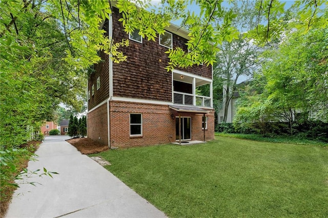 back of house with brick siding and a lawn