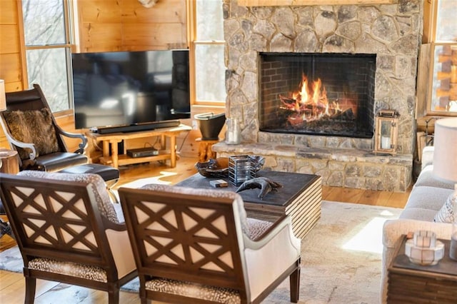 living room featuring wood-type flooring and a stone fireplace