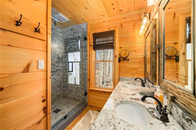 bathroom featuring vanity, a shower with shower door, wooden ceiling, and wood walls