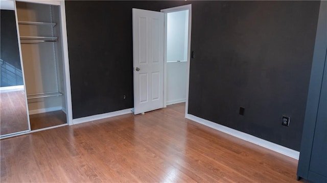 unfurnished bedroom with wood-type flooring and a closet