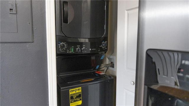 laundry area featuring stacked washing maching and dryer and electric panel