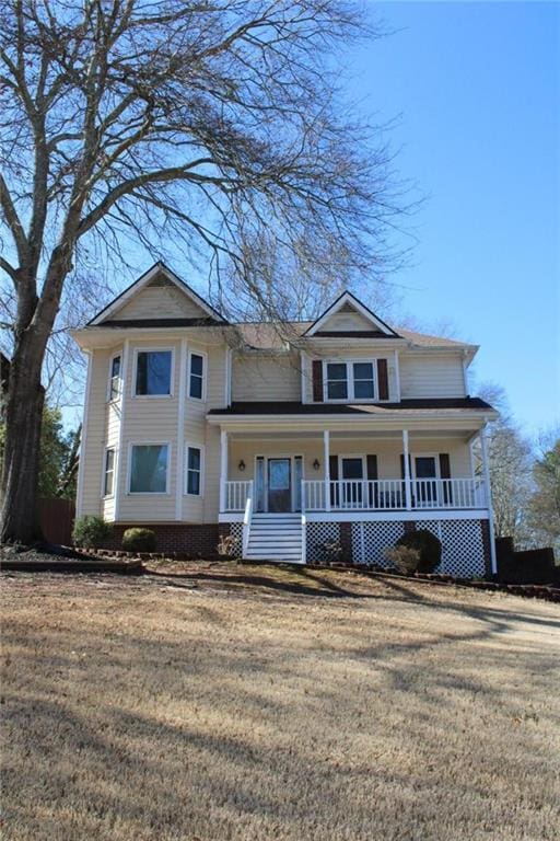 view of front of house with covered porch and a front lawn