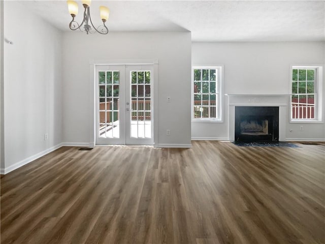 200 Eagle Glen Ct, Woodstock, GA 30189 - unfurnished living room featuring french doors, wood finished floors, baseboards, a chandelier, and a fireplace with flush hearth
