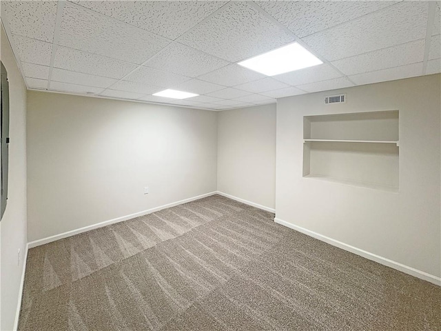 empty room featuring a paneled ceiling and carpet flooring