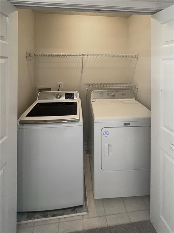 washroom featuring independent washer and dryer and light tile patterned floors