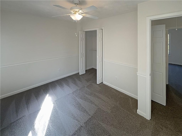 unfurnished bedroom featuring dark carpet and ceiling fan