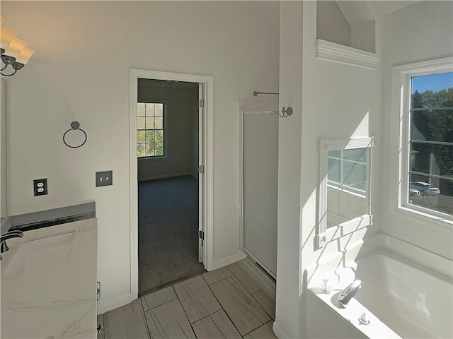 bathroom featuring independent shower and bath and vaulted ceiling