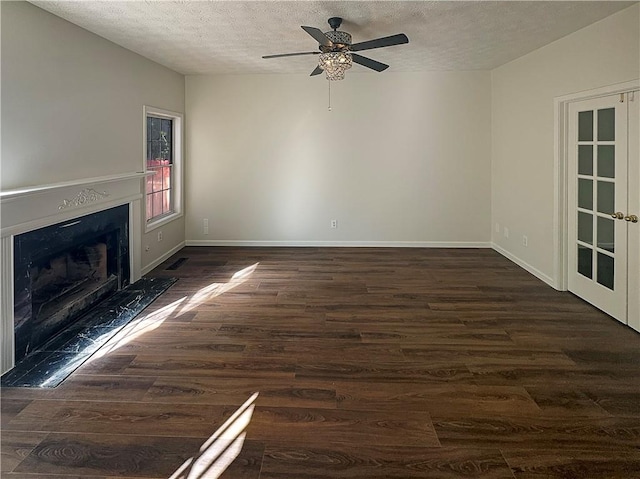 unfurnished living room featuring dark wood-type flooring, a textured ceiling, and ceiling fan