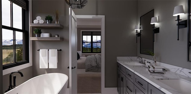 bathroom with a bath, vanity, a mountain view, and a wealth of natural light