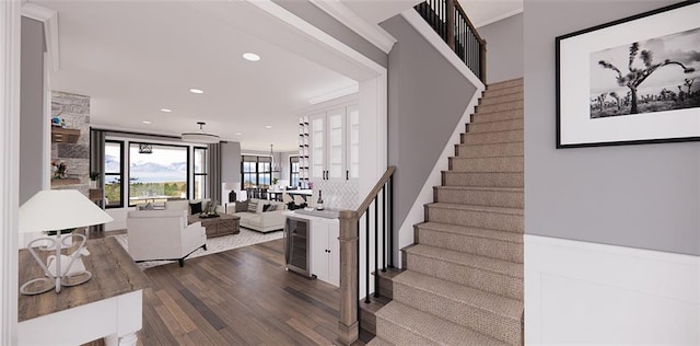 stairs with hardwood / wood-style flooring and ornamental molding