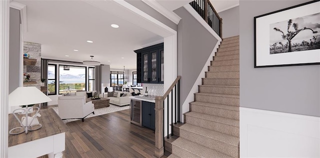 stairs featuring crown molding and hardwood / wood-style floors