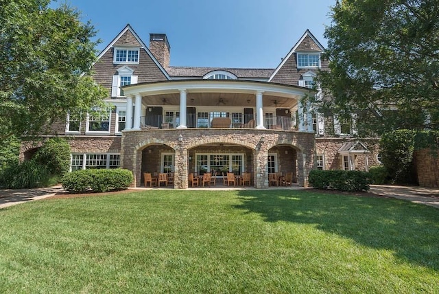 view of front of home with a balcony and a front yard